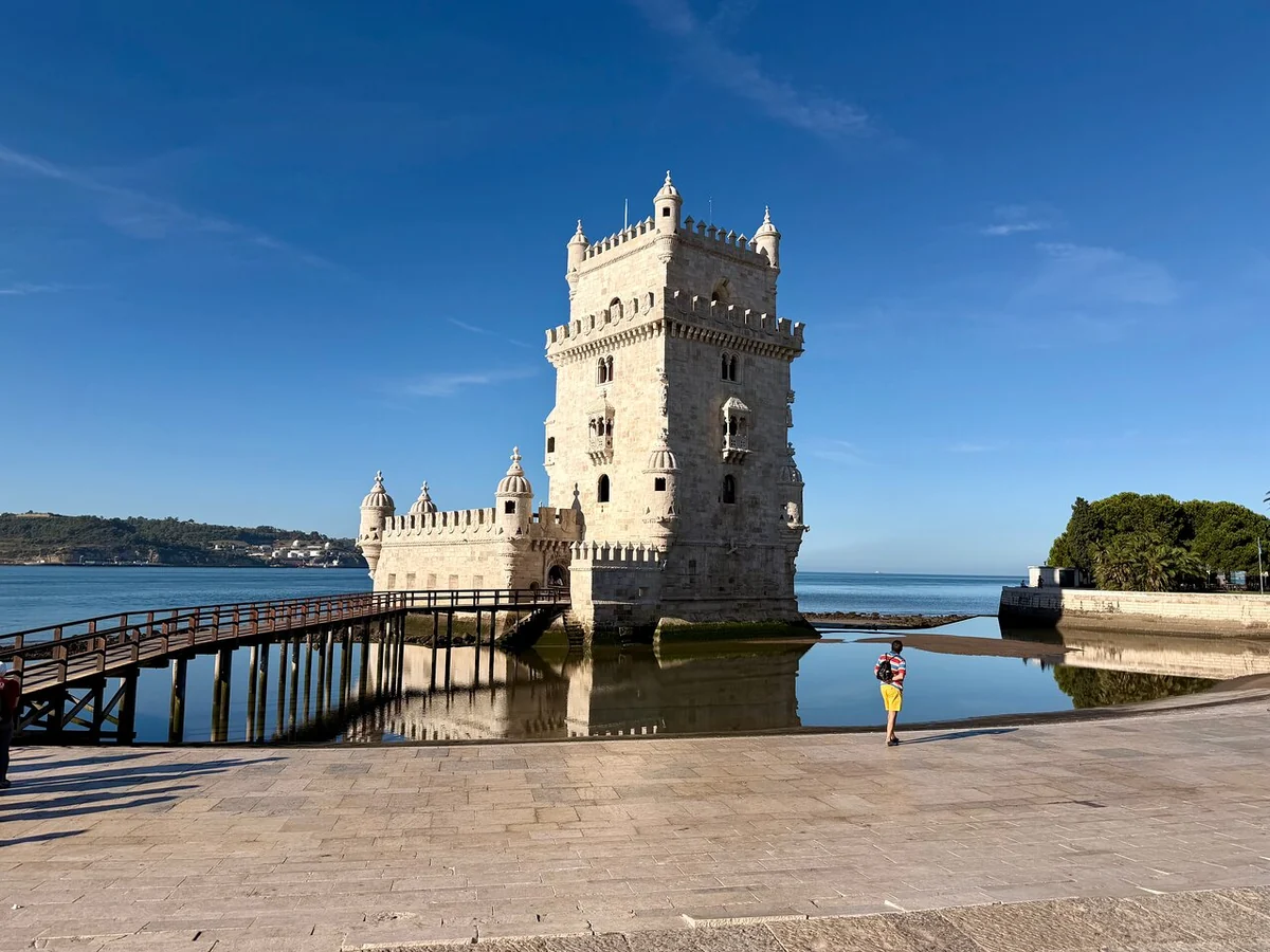 Belém Tower seen from the shore with the river behind it